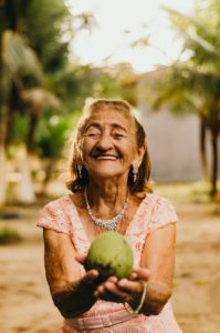 woman wearing pink dress holding fruit